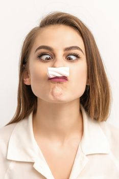 Young funny woman with sweet candy marshmallow-like mustache over white background. Depilation and epilation concept