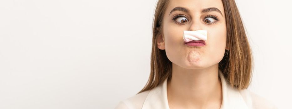 Young funny woman with sweet candy marshmallow-like mustache over white background. Depilation and epilation concept