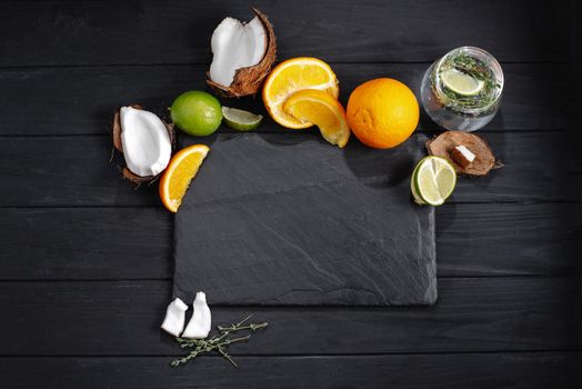 mock up slate with tropical fruits. Mockup Set of fruits tropical lime, coconut on, orange, the background of an old dark wooden table, top view, flat.