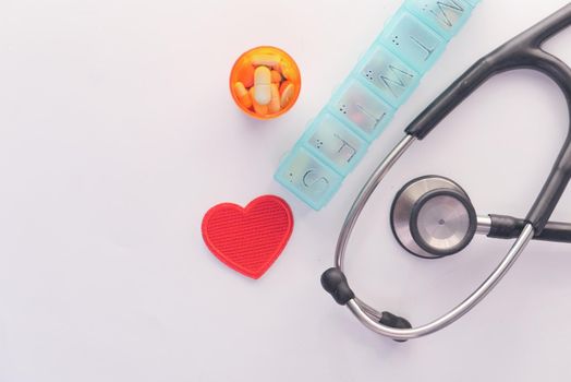 pill box and container stethoscope on white background .