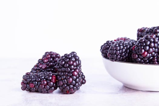 Blackberry berries. Black berries close-up on a wooden surface. Summer fruits are scattered on the table. Copyspace.