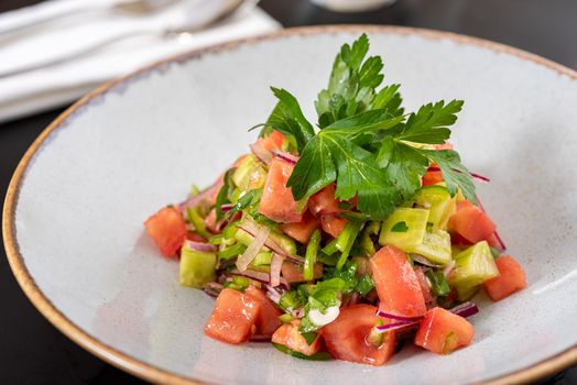 Turkish Coban (choban) salata or Shepherds salad on black table.