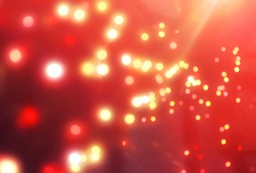 Red Christmas garland blurred and defocused with bokeh on a dark red background