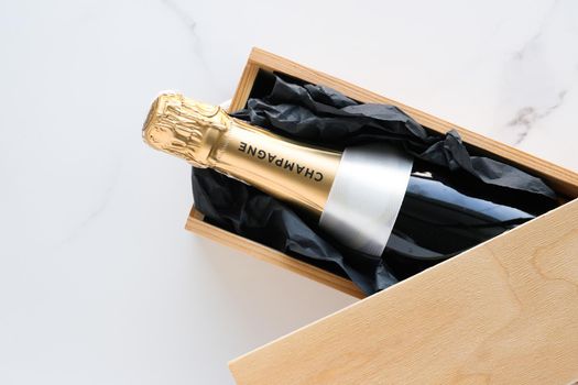 Wedding celebration, lifestyle and luxury present concept - A champagne bottle and a gift box on marble