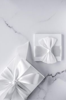 Romantic celebration, bridal decor and holiday present concept - Luxury wedding gifts with silk bow and ribbons on marble background