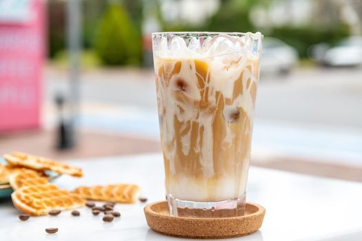 Iced caramel latte coffee in a tall glass with caramel syrup