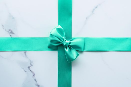 Holiday design, greeting card and vintage gift concept - Green silk ribbon on marble background, top view