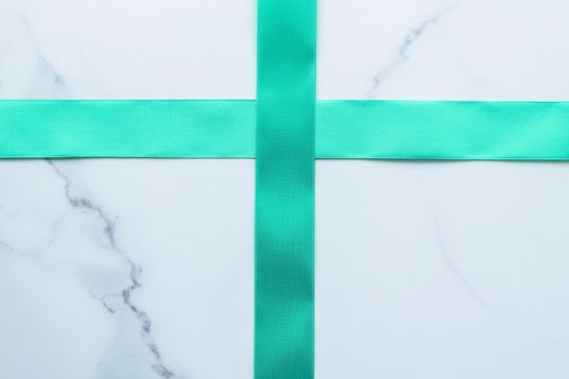 Holiday design, greeting card and vintage gift concept - Green silk ribbon on marble background, top view