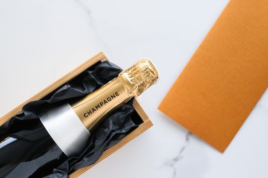 Wedding celebration, lifestyle and luxury present concept - A champagne bottle and a gift box on marble