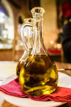 Natural food, Mediterranean diet and healthy eating concept - Bottles of organic extra virgin olive oil in Italian restaurant