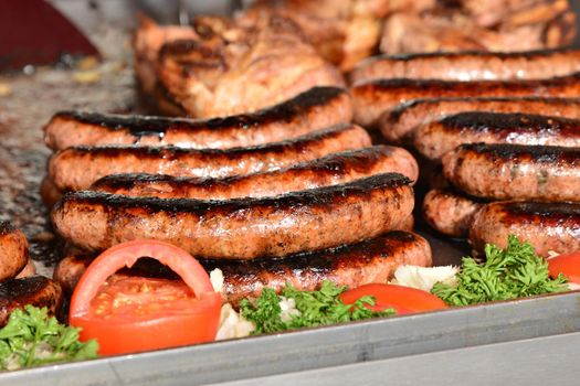 Fried sausages in a large frying pan on the market in Paris