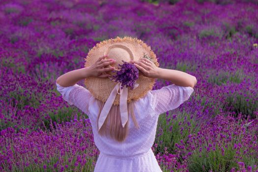 Woman in a field of lavender flowers in a white dress. Ukraine. selective focus