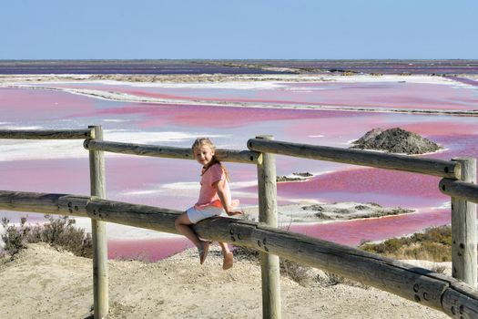 A girl at the Salin-de-Giraud salt farm with pink purple salty water