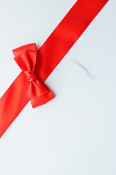 Holiday decor, feminine design and flatlay concept - Red silk ribbon on marble, top view