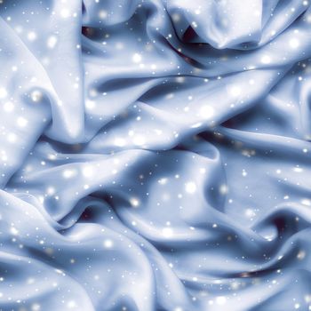 Winter fashion, shiny fabric and glamour style concept - Magic holiday blue soft silk flatlay background texture with glowing snow, luxury beauty abstract backdrop