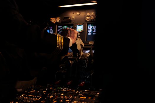 Male captain throttling engine to takeoff with aircraft jet, flying airplane with power dashboard command in cockpit. Airliners using radar switch on control panel navigation. Close up.