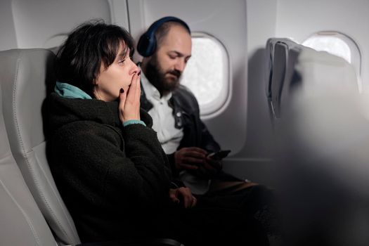 Woman feeling tense and scared about airplane takeoff, being frightened about flying abroad. Travelling with international airways to go on holiday adventure, commercial flight.