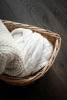 Knitwear, fabric textures and rustic lifestyle concept - Knitted winter clothes in a basket