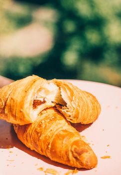 Fresh croissant, summer breakfast outdoors - sweet food, French pastry and eating outside concept. Good morning, darling
