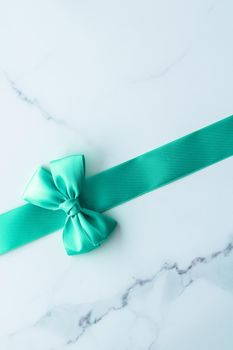 Holiday design, greeting card and vintage gift concept - Green silk ribbon on marble background, top view