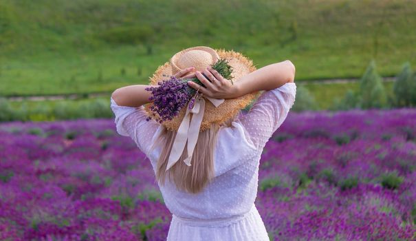 Woman in a field of lavender flowers in a white dress. Ukraine. selective focus