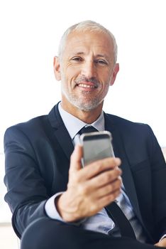 Technology helps me do more. Portrait of a mature businessman texting on a cellphone in an office