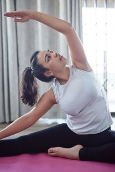 Fitness comes first for her. an attractive young woman working out at home