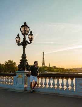 Alexander bridge Paris, view of the famous landmark Alexander III bridge in Paris, the capital of France. Young men viewing at the Eiffel tower during sunset