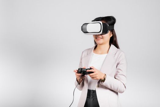 Smile woman confidence excited wear 3D VR headset device and playing game virtual reality experience with joystick isolated white background, Asian happy female play video game studio shot,copy space