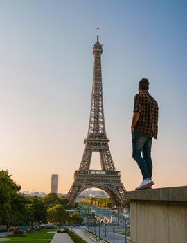 Young men watching sunrise by the Eiffel tower, Eiffel tower at Sunrise in Paris France, Paris Eifel tower on a summer day in the city of Paris France