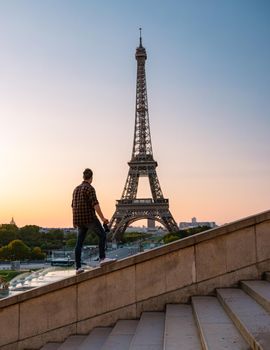 Young men watching sunrise by the Eiffel tower, Eiffel tower at Sunrise in Paris France, Paris Eifel tower on a summer day in the city of Paris France