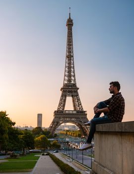 Young men watching sunrise by the Eiffel tower, Eiffel tower at Sunrise in Paris France, Paris Eifel tower on a summer day in the city of Paris France