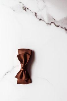 Holiday gift, decoration and sale promotion concept - Chocolate brown silk ribbon on marble background, flatlay