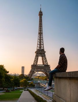 Young men watching sunrise by the Eiffel tower, Eiffel tower at Sunrise in Paris France, Paris Eifel tower on a summer day in the city of Paris France