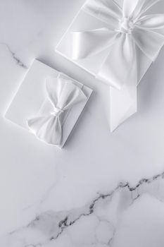 Romantic celebration, bridal decor and holiday present concept - Luxury wedding gifts with silk bow and ribbons on marble background