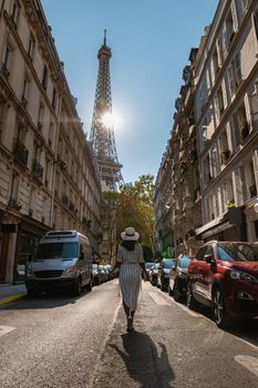 Young women with a hat visiting Eiffel tower at Sunrise in Paris France, Paris Eifel tower on a summer day in the city of Paris France