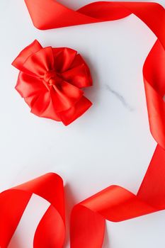 Holiday decor, feminine design and flatlay concept - Red silk ribbon on marble, top view