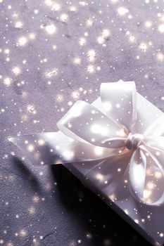 New Years Eve celebration, wrapped luxury box and Valentines Day card concept - Winter holiday gift and glowing snow background, Christmas presents surprise