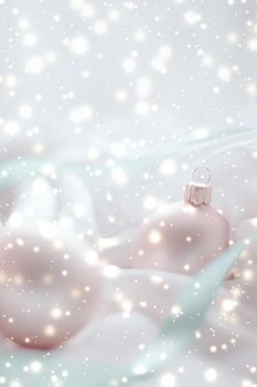 Winter, celebration and new years eve concept - Christmas decoration with shiny snow on silk background, holiday season