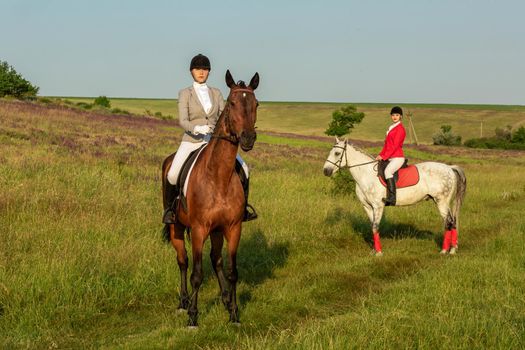 Two young women riding horse in park. Horse walk in summer. Outdoor photography in lifestyle mood