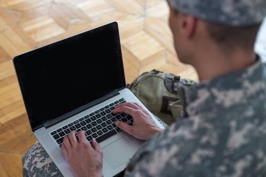 Soldier holding laptop. Military education concept.