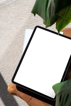 Digital tablet computer with isolated screen on office desk for mockup design. At home interior.