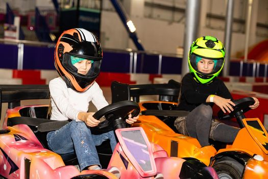 two little girls on children's toy cars.