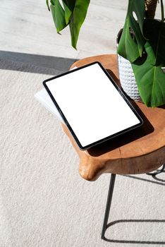 Digital tablet computer with isolated screen on office desk for mockup design. At home interior.