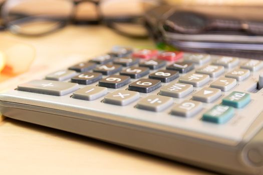 close up calculator equipment for income, expenditure, calculation on wood table