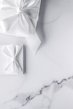 Romantic celebration, bridal decor and holiday present concept - Luxury wedding gifts with silk bow and ribbons on marble background