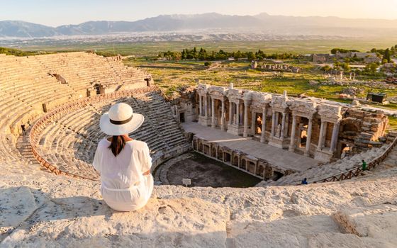 Hierapolis ancient city Pamukkale Turkey, a young Asian woman with a hat watching the sunset by the ruins Unesco site during summer