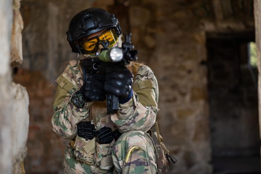 A woman in an army uniform shoots a firearm in an abandoned building