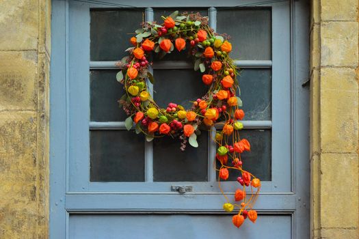 Wreath of autumn plants with physalis and red berries