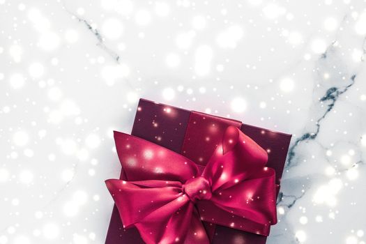 New Years Eve celebration, wrapped luxury boxes and cold season concept - Winter holiday gifts with cherry silk bow and glowing snow on frozen marble background, Christmas presents surprise